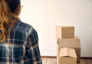 rearview shot of a woman looking at boxes in an empty room